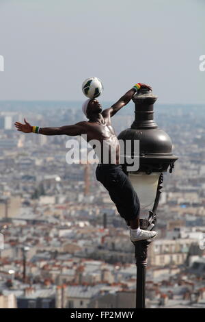 akrobatische Performance-Künstlerin in einem alten Gaslampe auf die Hügel von Sacre Coeur in Montmartre Paris Stockfoto