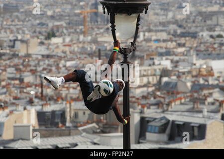 akrobatische Performance-Künstlerin in einem alten Gaslampe auf die Hügel von Sacre Coeur in Montmartre Paris Stockfoto