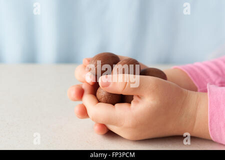 Des Kindes Hände halten Schokoladeneier mit coopy Raum. Seitenansicht Stockfoto