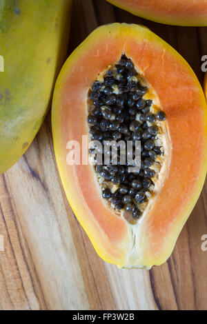 Nahaufnahme von einer Papaya halbieren enthüllt das Fleisch und ein Haufen von dunklen schleimigen Samen Stockfoto