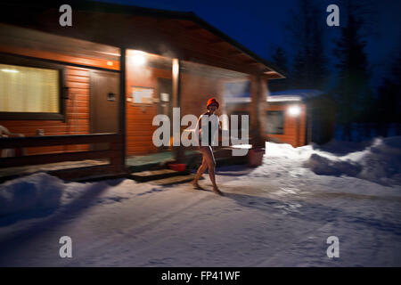 Die Leute nehmen eine Sauna in einem Häuschen neben dem Fluss Kemi, Salla, Lappland, Finnland. Atemberaubende Sauna-Erlebnis. Eine finnische Fitn Stockfoto