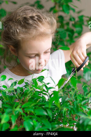 Niedliche kleine Mädchen mit Blumen zu Hause arbeiten. Stockfoto