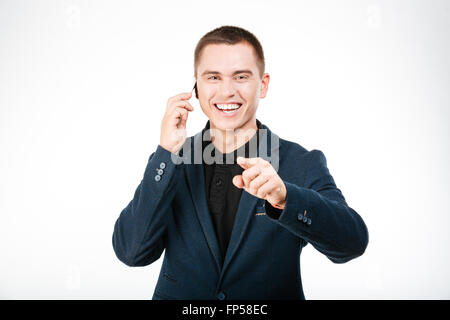 Lachende Geschäftsmann am Telefon sprechen und Finger auf Kamera isoliert auf weißem Hintergrund Stockfoto