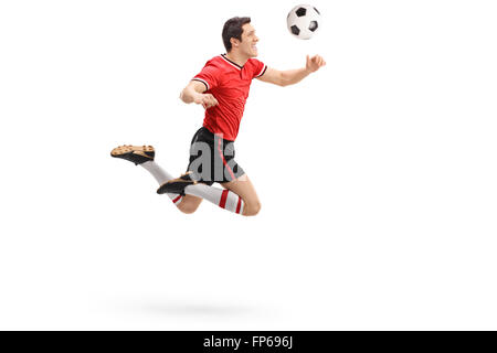 Studioaufnahme eines jungen Fußballspielers in Richtung einer Kugel erschossen in der Luft isoliert auf weißem Hintergrund Stockfoto