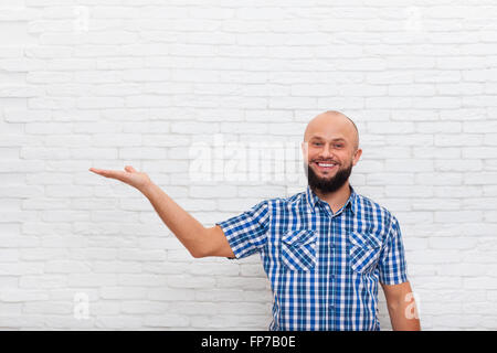 Lässige bärtiger Mann lächelnd offenen Handfläche Handbewegung um Leerzeichen kopieren Stockfoto