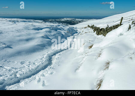 Trail im tiefen Schnee auf der Strecke zwischen Hayfield und Edale, in der Nähe von Edale Cross, Peak District, Derbyshire, England, UK Stockfoto