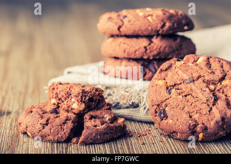 Schokolade Keks Cookies. Schokoladen-Plätzchen auf weißem Leinen Serviette auf Holztisch. Stockfoto