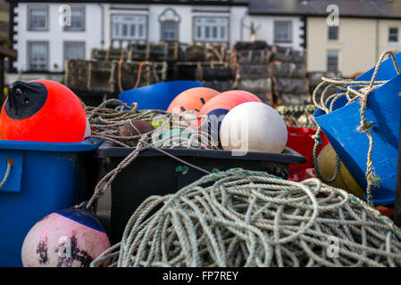 Eine Nahaufnahme von Lobster Pot Angeln Ausrüstung Kisten mit Seil gefärbt schwimmt auf dem Kai an Aberdyfi Wales. Stockfoto