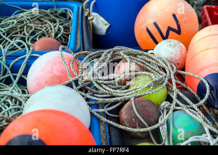 Eine Nahaufnahme von Lobster Pot Angeln Ausrüstung Kisten mit Seil gefärbt schwimmt auf dem Kai an Aberdyfi Wales. Stockfoto