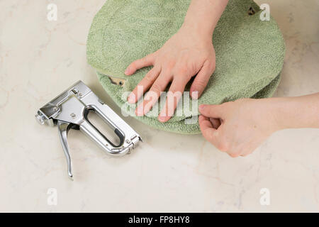 einen Teil des Stuhls Polsterung durch Tacker Stockfoto