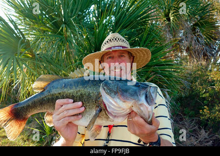 Ein Fischer in Florida, USA, eine große Largemouth Bass Fisch hält Stockfoto