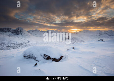 Die verschneiten Berge (links nach rechts: Beinn Eighe, Liathach, Beinn Dearg und Beinn Alligin) von Torridon bei Sonnenuntergang, vom Gipfel des Beinn A' Chearcail Stockfoto