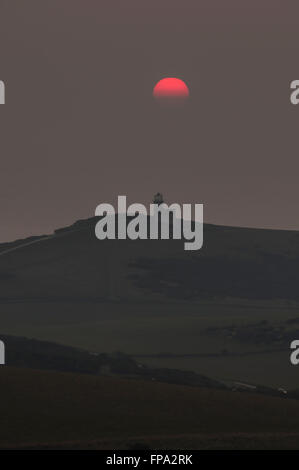 Eastbourne, East Sussex, Großbritannien. März 2016. Glorreiches Ende des St. Patricks Day, als die Sonne im Nebel über dem Leuchtturm von Belle Tout steht Stockfoto