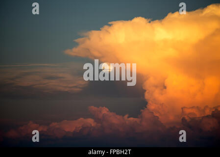 Full Moon rising hinter bunt leuchtenden Gewitterwolken durch den Sonnenuntergang Ath beleuchtet die Schweizer Alpen im Sommer Stockfoto