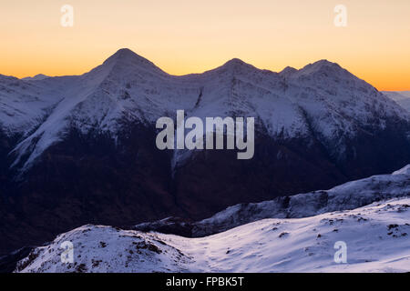 Der zerklüftete Kintail-Grat, wenn die Dämmerung an einem klaren Wintermorgen bricht, Kintail, Schottland, von Sgurr Mhic Bharraich im Winter Stockfoto