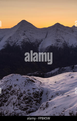 Zwei der fünf Schwestern von Kintail (Sgurr Fhuaran und Sgurr na Carnach) verwandeln sich im Winter von Sgurr Mhic Bharraich in Sonnenaufgang Stockfoto