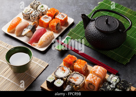 Satz von Sushi und Maki-Rolle und grünem Tee am Steintisch Stockfoto