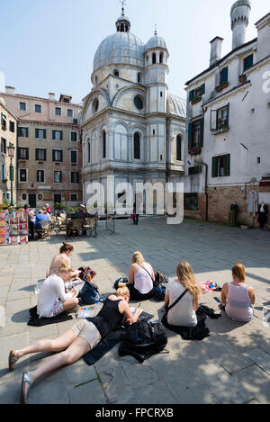 Junge Frauen eine Zeichenschule auf dem Boden des Campo Santa Maria Nova Quadrat zeichnen die Kirche Santa Maria dei Miracoli, Venedig Stockfoto