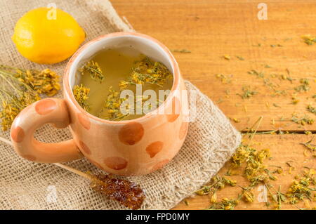 St Johns Johanniskraut Tee und umgeben von getrockneten Kantarion Pflanzen Stockfoto