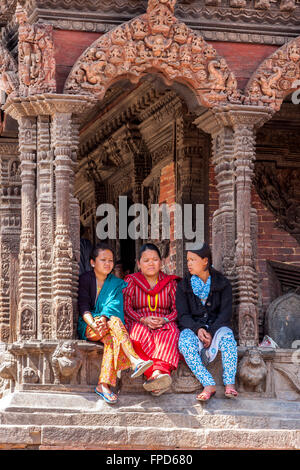 Nepal, Patan.  Nepalesische Frauen reden im Schatten der Vishwanath Tempel, Durbar Square.  Der Tempel überlebte das Erdbeben von 2015. Stockfoto