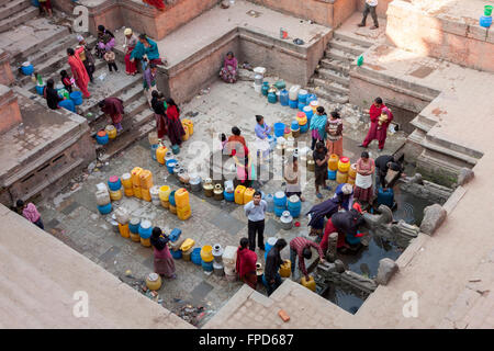 Nepal, Patan.  Männer und Frauen aufgereiht am Manga Hiti, eine öffentliche Wasser Brunnen dienen Bewohner, die kein Wasser laufen. Stockfoto