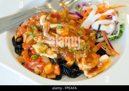 Schwarze Spaghetti mit Meeresfrüchten auf weißen Teller Stockfoto