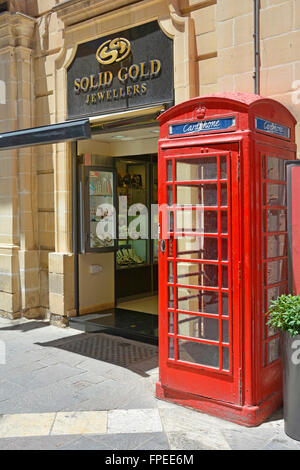 Valletta Malta Republic Street rot UK Stil Telefonzelle neben Juwelier Shop auf verkehrsberuhigten Einkaufsstraße Stockfoto