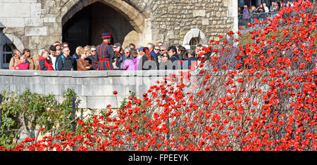 Überlappende Bereich der Keramik Mohnblumen "Blut fegte Ländereien & Meere rot" 1. Weltkrieg Tribut Tower of London mit Yeoman Warder Tour für Gruppe von Touristen Stockfoto