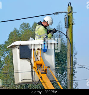 Elektro-Ingenieur, die Durchführung von Reparaturen an Freileitungen im Wohngebiet Straße arbeiten von einem LKW montiert hydraulische fröhlichen Picker Hebezeug UK Stockfoto