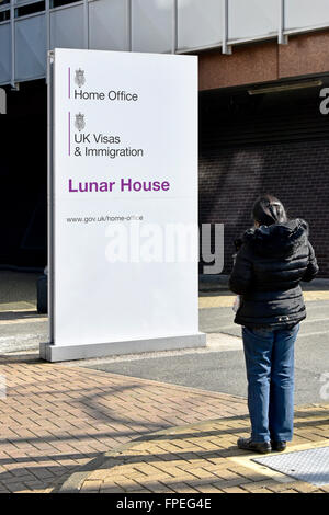 Unbekannte Person mit unbekanntem Wohnsitzstatus vor dem Home Office schaut Schild Regierungsbüros Lunar House Croydon South London England Großbritannien Stockfoto