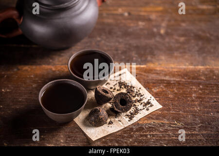 Tassen chinesischer Pu-Erh Tee auf hölzernen Hintergrund Stockfoto