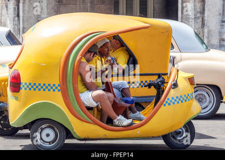 Havanna, Kuba - 1. April 2012: Hispanic junge Frau mit Mittagessen in gelbes Taxi Motorrad Stockfoto