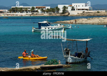 ELS Pujols Strand auf Formentera mit traditionellen Fischerboot und Kajaks im Sommertag. Llaüt Boote. Stockfoto