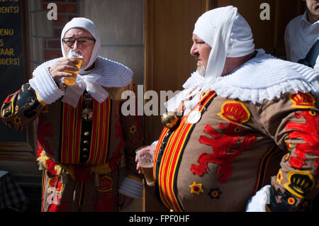 Demonstration der Karneval von Binche Kleider, Brüssel, Belgien. UNESCO World Heritage Parade Festival. Belgien. Wallonischen Gemeinde, Provinz Hennegau. Zwei belgische Festivalteilnehmer Binche Bier trinken mit ihren traditionellen Kostümen: orientalische Fürsten, Matrosen und Harlekine auch durch die Straßen von Brüssel. Eine erstaunliche Prozession durch die gepflasterten Straßen der Stadt im Takt der Trommeln und Künstler mit Wachs Masken und Straußenfedern. ein Erlebnis. Stockfoto