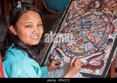 Nepal, Patan.  Junge Frau ein Thangka Malerei ein tibetisch-buddhistische Gemälde. Stockfoto