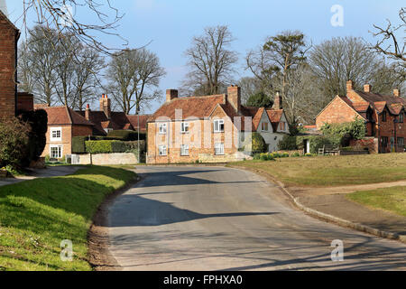 Straßenlauf durch eine englische ländliches Dorf mit malerischen Häusern und Dorfanger Stockfoto