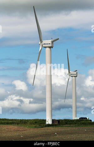 Zwei drei Klinge Windturbinen Hochformat auf Land bewölktem Himmel Erzeugung grüner Strom aus freien Windversorgung von Natur. Gefahr für Vögel. Stockfoto