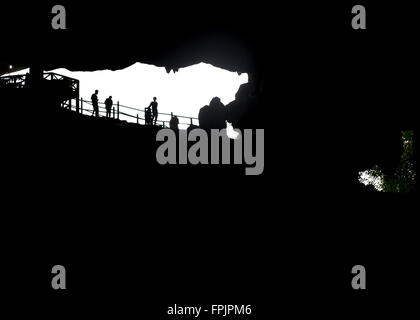 Halong Bucht, Vietnam Blick aus dem Inneren der Hang Sung Sot Grotte mit touristischen Silhouetten im Eingangsbereich, Stockfoto