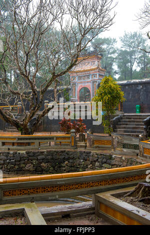 Innenhöfe, Garten und verzierte Tor an der Tu Duc Mausoleum, Vietnam, im Regen Stockfoto