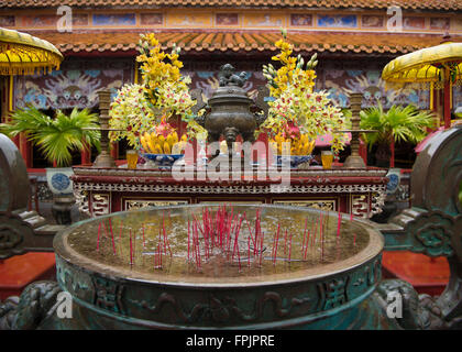 Buddhistischen Schrein mit riesigen überschwemmten Weihrauch Stockhalter und Obst, Blumen und Getränke angeboten.  Im Regen Stockfoto