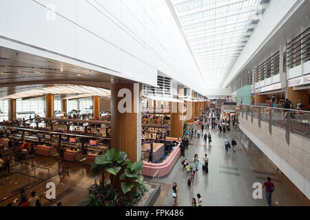 Eine nostalgische Szene einer geschäftigen Abflughalle am Terminal 2 des Flughafens Changi in Singapur. Stockfoto