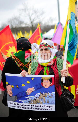 Hannover, Deutschland. 19. März 2016. Eine kurdische Demonstranten hält eine Fahne mit einem Cartoon von Angela Merkel und der türkische Präsident Erdogan während einer Demonstration in Hannover, 19. März 2016. Nach Angaben der Polizei teilnehmen 6.000 Demonstranten an die Ankündigung für die kurdischen Newroz-fest. Foto: Alexander Koerner/Dpa/Alamy Live News Stockfoto