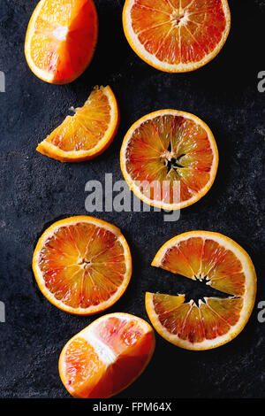 Sizilianischen Blut Orangen Früchte über schwarzem Metall geschnitten. Ansicht von oben Stockfoto