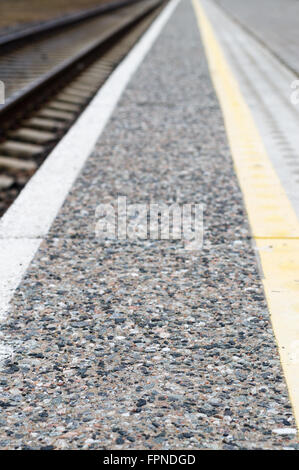 Perspektivansicht Muster am Rand der Plattform, der Eisenbahnstrecken zu warnen Stockfoto