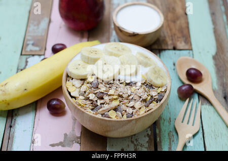 Frühstück: hausgemachte Joghurt mit Haferflocken in Schüssel auf Holztisch Stockfoto