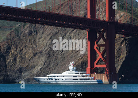 Yacht unterquert die Golden Gate Bridge an einem sonnigen Tag Stockfoto