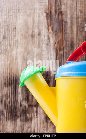 Gießkanne Closeup auf Hintergrund der alten Holzbrett Stockfoto