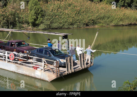 Betreiber ziehen eine handgezeichnete Fähre über den Rio Grande Fluss in Los Ebanos, Texas, USA Stockfoto