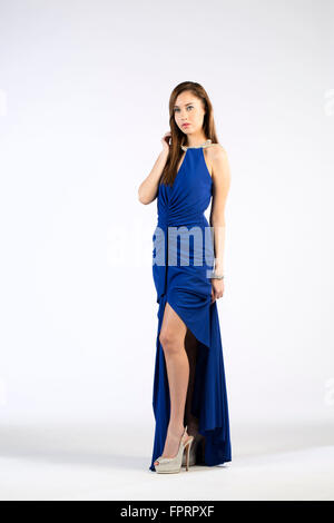Ein Model trägt ein langes Kleid Schuss gegen ein Weiß Hintergrund Stockfoto