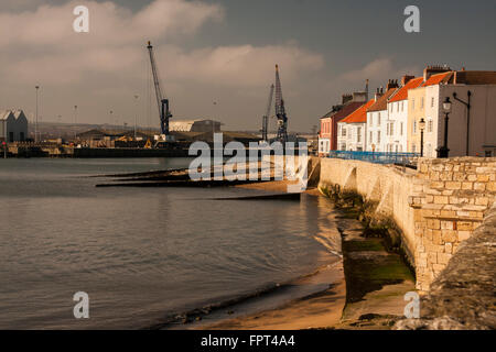 Ein Blick auf die Landzunge bei Hartlepool im Nordosten Englands zeigt Häuser, Strand und Krane Stockfoto